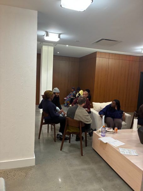 A group of people seated around a table in a cozy indoor setting.